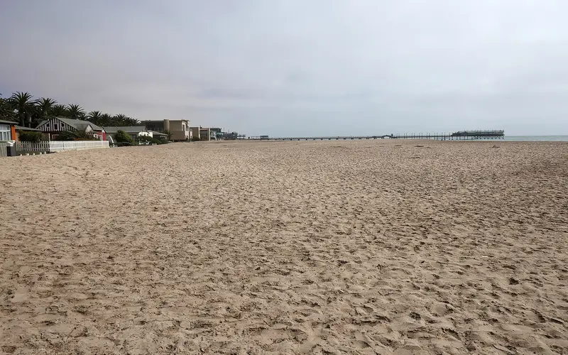 Sandy beach in Swakopmund with the historic jetty in the distance
