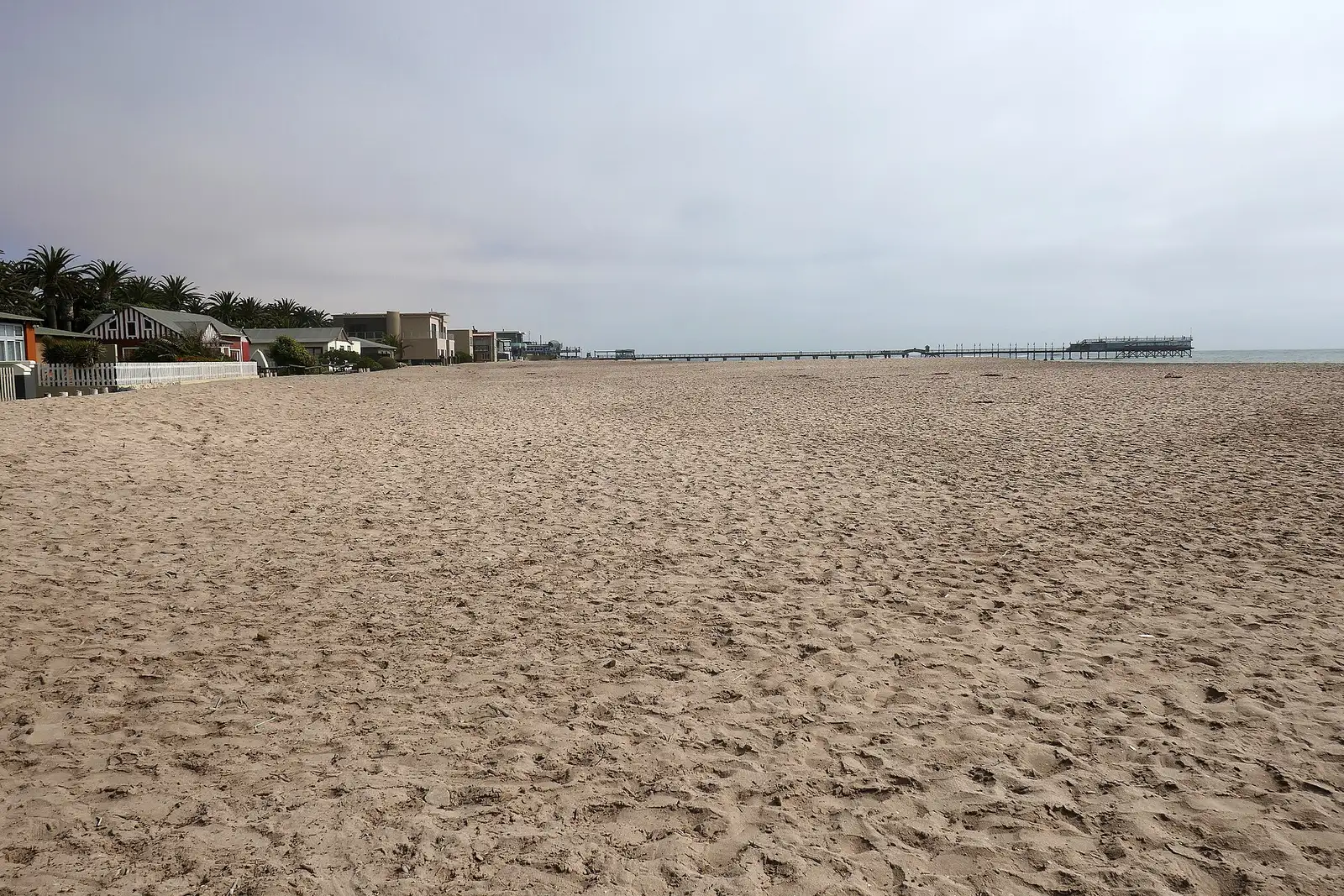 Sandy beach in Swakopmund with the historic jetty in the distance