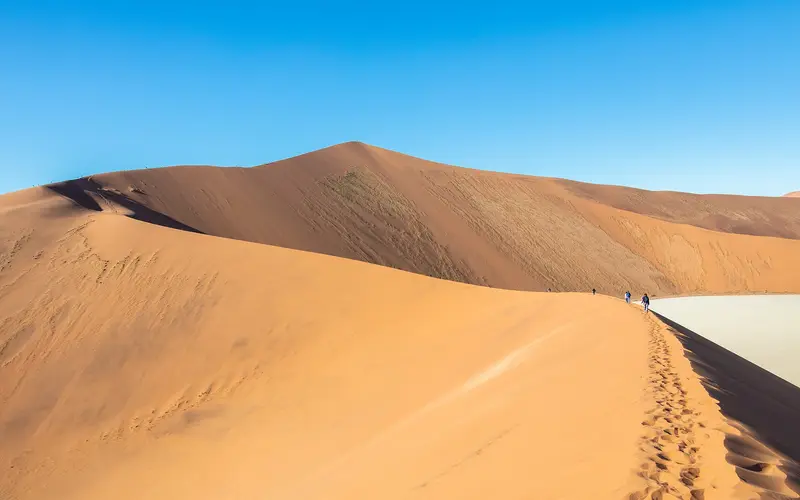 Hikers walking along a dune ridge in Sossusvlei